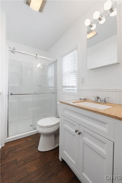full bathroom featuring vanity, a stall shower, toilet, and wood finished floors