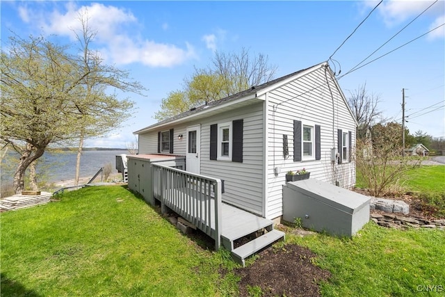 rear view of house featuring a yard and a deck with water view