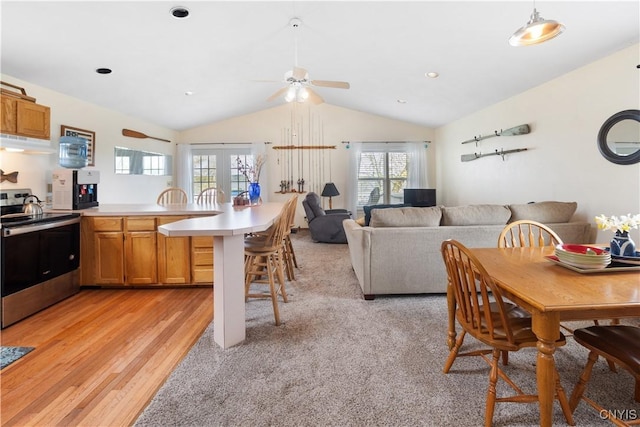 kitchen with stainless steel range with electric stovetop, a peninsula, a breakfast bar area, ceiling fan, and under cabinet range hood
