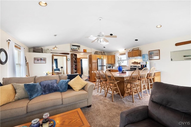 living area featuring vaulted ceiling, light carpet, and a ceiling fan