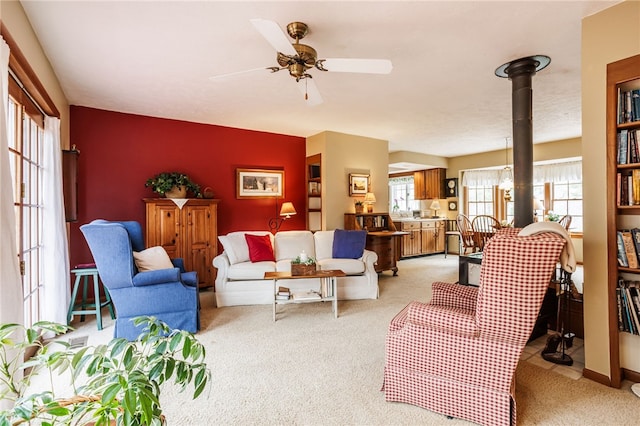 living area with a ceiling fan and light carpet