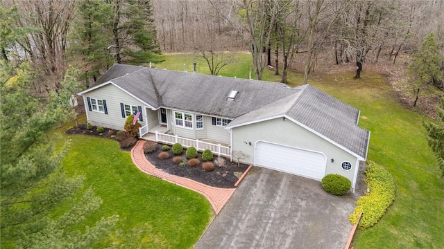 view of front of property with aphalt driveway, a front yard, roof with shingles, an attached garage, and a porch