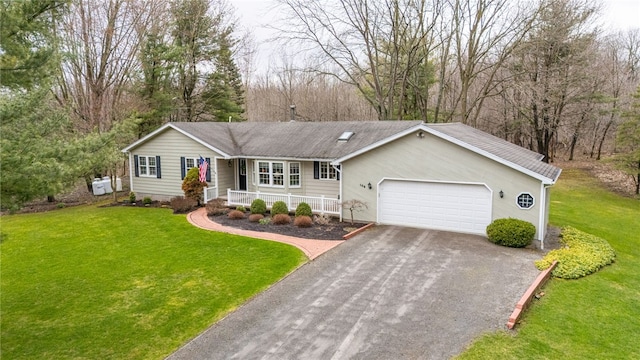 ranch-style home featuring a garage, aphalt driveway, covered porch, and a front yard