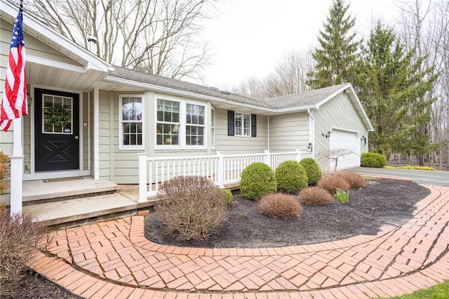 exterior space with an attached garage, driveway, and roof with shingles