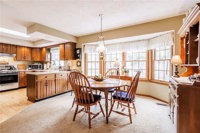 dining area featuring baseboards, light carpet, and visible vents