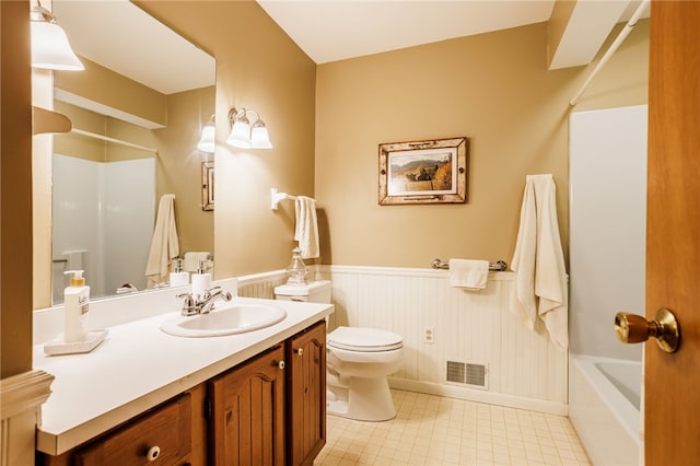 bathroom with vanity, wainscoting, toilet, and visible vents