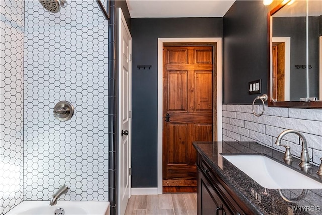 bathroom featuring vanity, decorative backsplash, a tile shower, and a tub