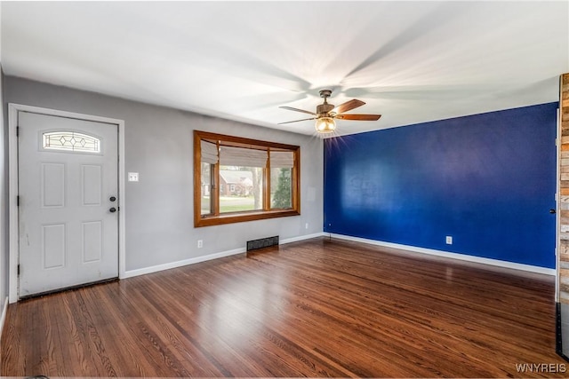 foyer entrance featuring baseboards, ceiling fan, wood finished floors, and visible vents