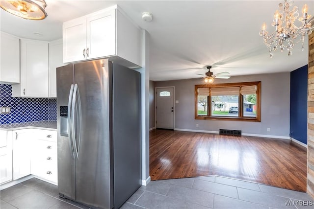 kitchen featuring tile patterned floors, ceiling fan with notable chandelier, white cabinetry, tasteful backsplash, and stainless steel refrigerator with ice dispenser