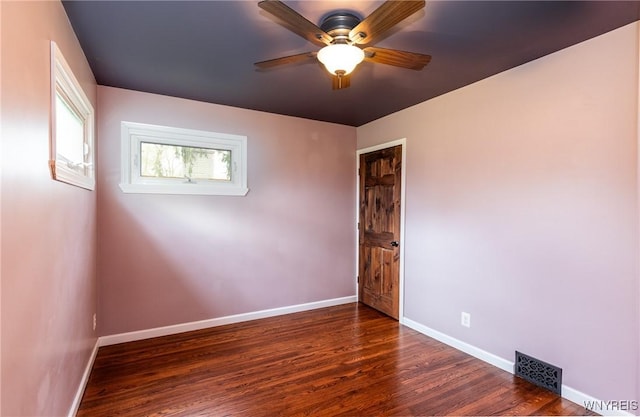 empty room featuring a ceiling fan, baseboards, visible vents, and wood finished floors