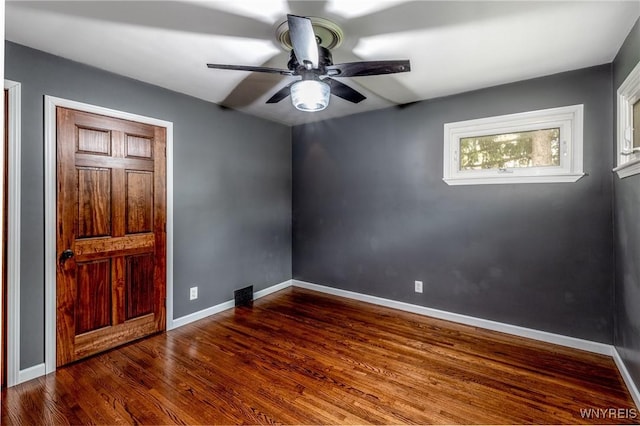 unfurnished room featuring a ceiling fan, baseboards, and wood finished floors