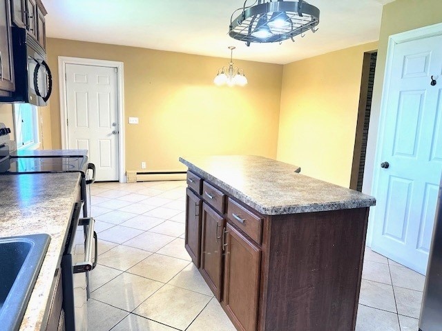 kitchen with a notable chandelier, black microwave, decorative light fixtures, light tile patterned floors, and a baseboard radiator