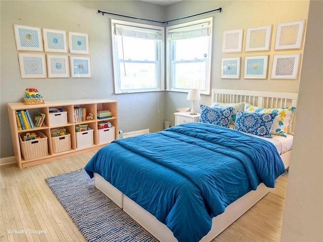 bedroom with baseboards and hardwood / wood-style flooring