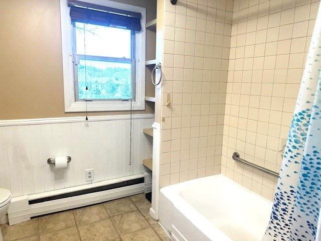 bathroom featuring a baseboard radiator, shower / bathtub combination with curtain, a wainscoted wall, and toilet