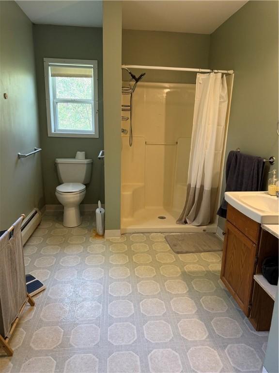 bathroom with baseboards, a shower stall, toilet, and a baseboard heating unit