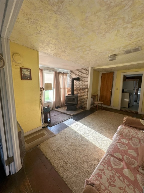 16 School St, Moravia, NY 13118 - living area with wood-type flooring, a wood stove, and washer / clothes dryer
