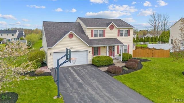 traditional home with fence, a porch, a front lawn, and aphalt driveway