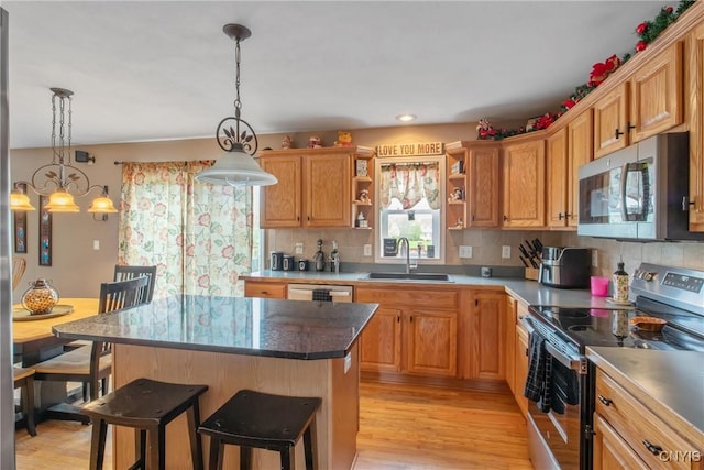 kitchen with open shelves, a sink, stainless steel appliances, decorative backsplash, and a kitchen bar