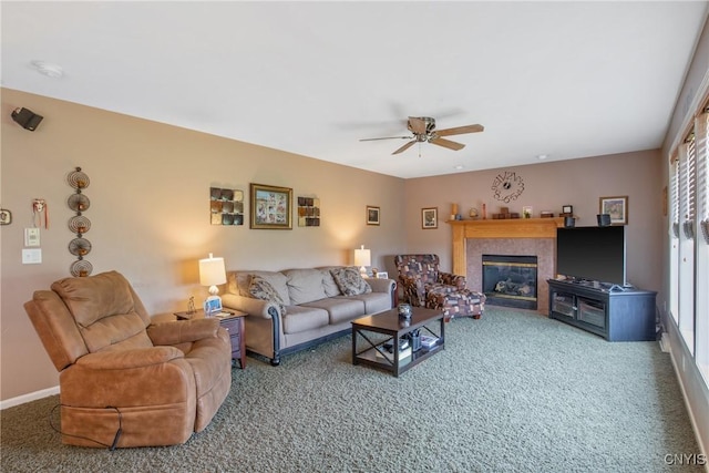 living room featuring baseboards, carpet, ceiling fan, and a glass covered fireplace