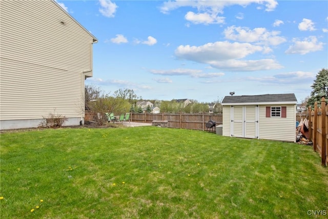 view of yard with a fenced backyard, an outbuilding, and a shed