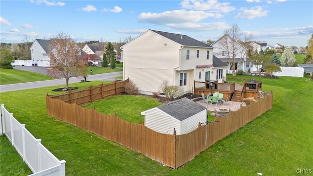 back of property with a lawn, a residential view, a wooden deck, and a fenced backyard
