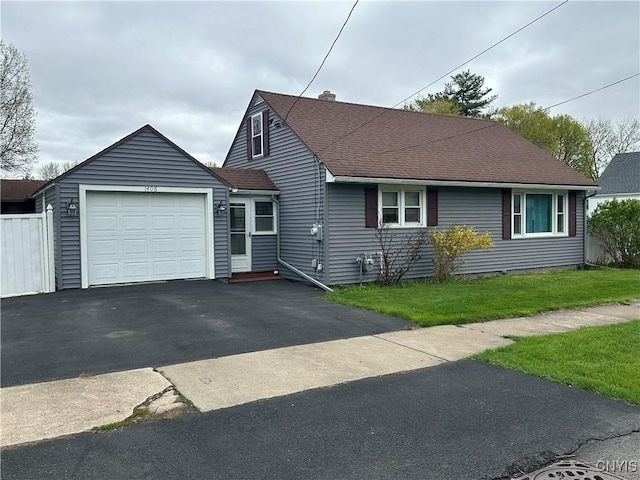 view of front of home with a garage, a shingled roof, aphalt driveway, and a front yard