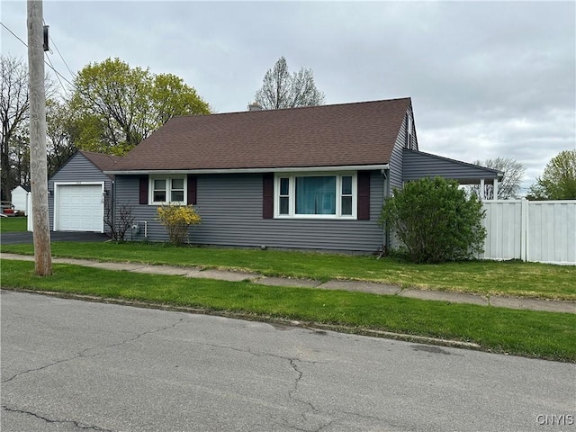 ranch-style house featuring aphalt driveway, a chimney, a garage, fence, and a front lawn