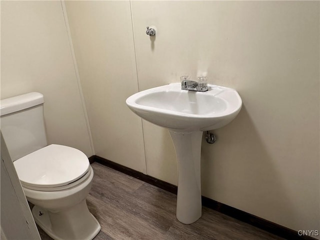 bathroom featuring toilet, baseboards, and wood finished floors