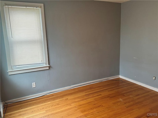 unfurnished room featuring baseboards and wood finished floors