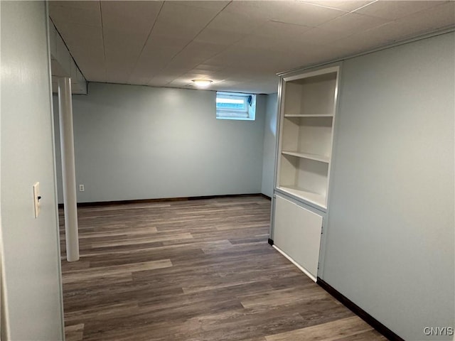 below grade area featuring baseboards and wood finished floors