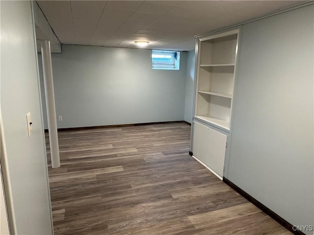 below grade area featuring baseboards and wood finished floors