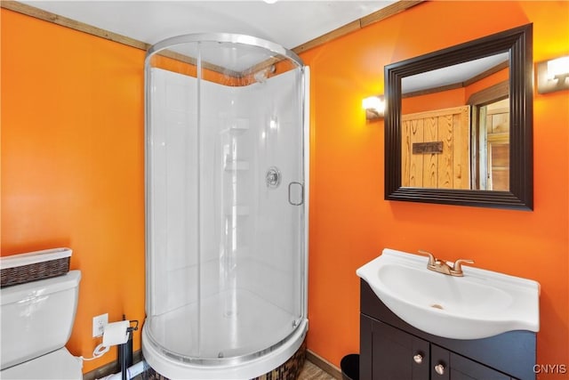 full bath with vanity, a shower stall, and toilet