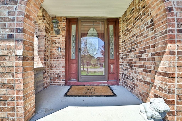 entrance to property featuring brick siding