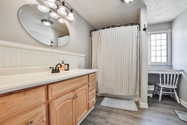 full bath featuring vanity, a textured ceiling, wood finished floors, and curtained shower