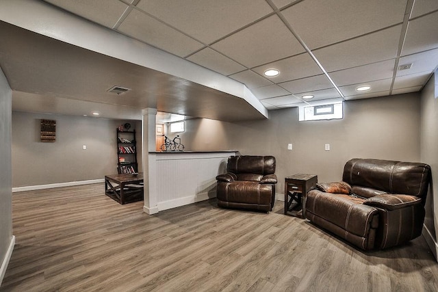 cinema featuring baseboards, visible vents, a paneled ceiling, and wood finished floors