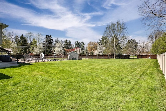 view of yard featuring a fenced backyard and a shed