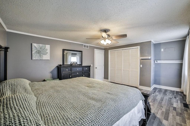 bedroom featuring visible vents, ornamental molding, a textured ceiling, and wood finished floors