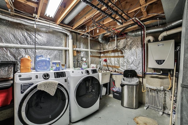 clothes washing area featuring laundry area, tankless water heater, and washing machine and clothes dryer
