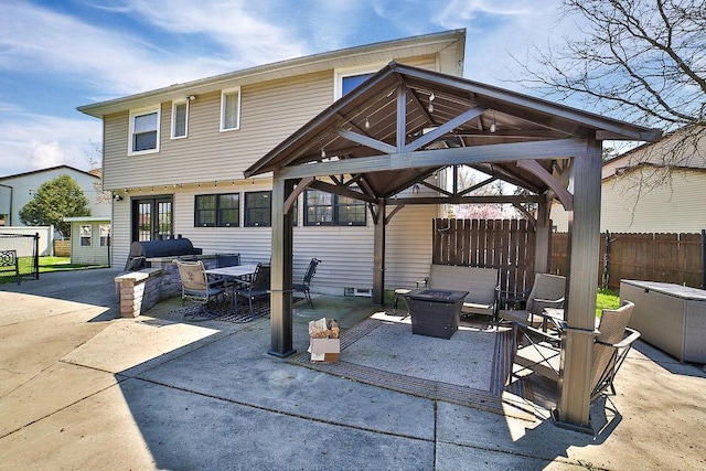 view of patio / terrace with fence, a gazebo, and a fire pit