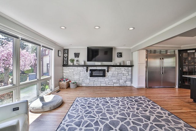 living room with ornamental molding, recessed lighting, and wood finished floors