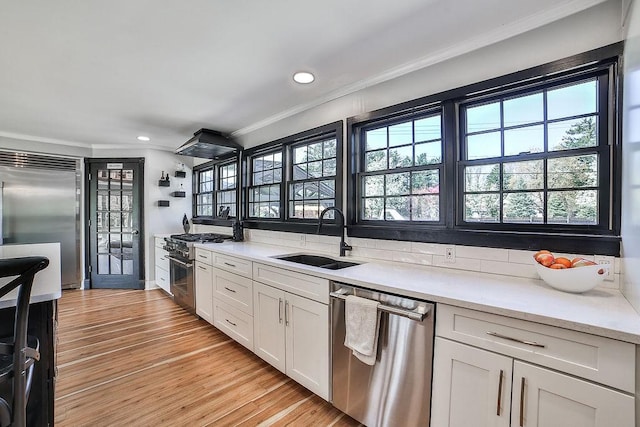 kitchen with crown molding, high quality appliances, recessed lighting, and a sink