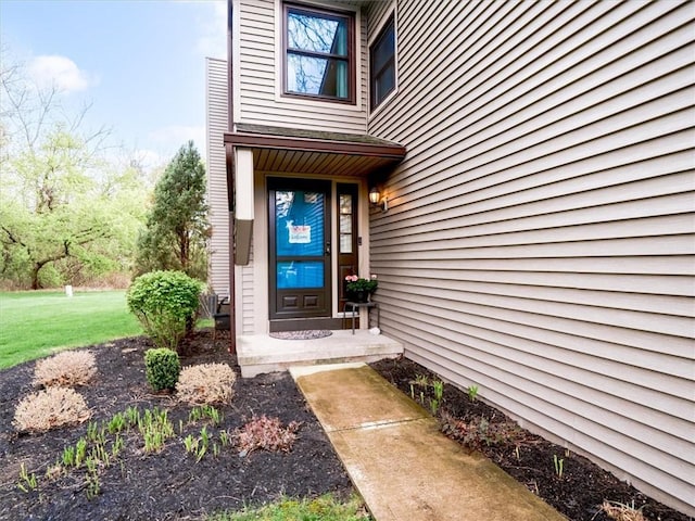 view of exterior entry with a lawn