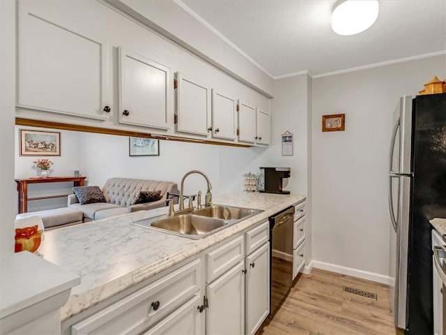 kitchen with freestanding refrigerator, ornamental molding, light wood-style floors, a sink, and dishwasher