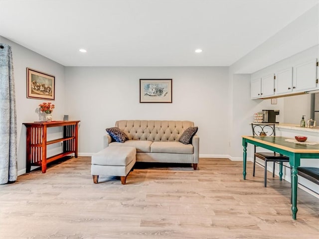 living room featuring recessed lighting, baseboards, and light wood-type flooring