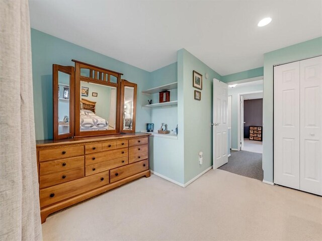 carpeted bedroom featuring baseboards and a closet