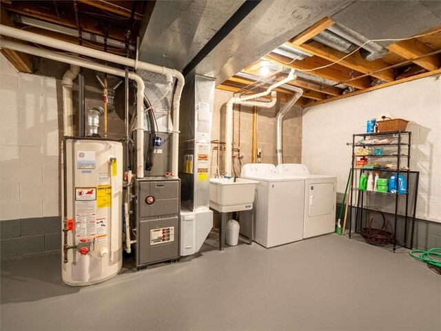 unfinished below grade area with heating unit, gas water heater, and washing machine and dryer