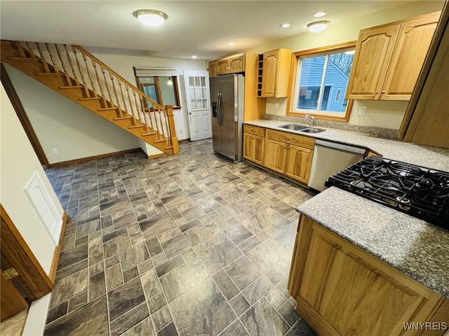 kitchen featuring appliances with stainless steel finishes, a sink, baseboards, light countertops, and recessed lighting