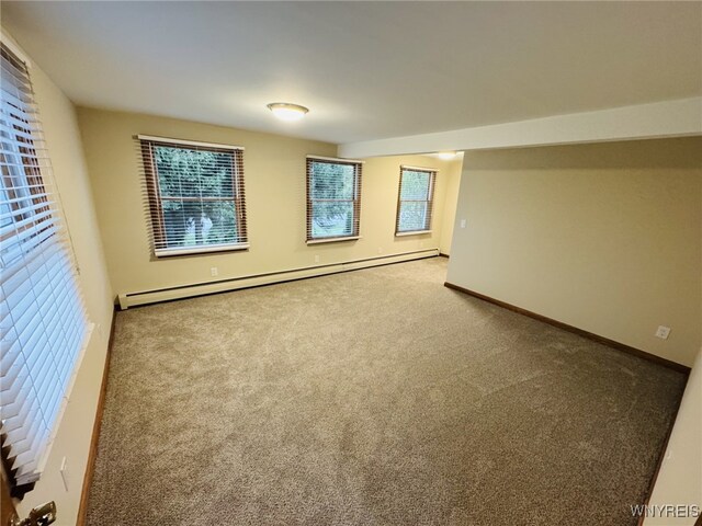 carpeted spare room with baseboards and a baseboard radiator