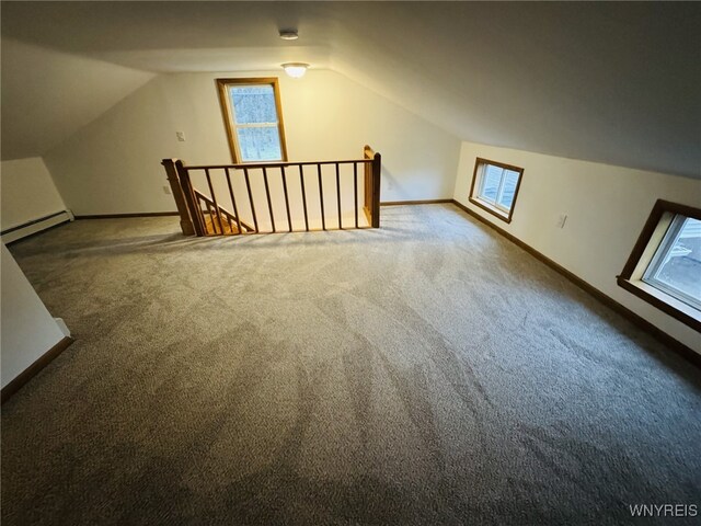 additional living space with carpet flooring, baseboards, vaulted ceiling, and a baseboard radiator