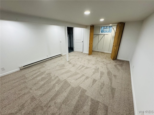 finished below grade area featuring recessed lighting, baseboards, baseboard heating, and light carpet